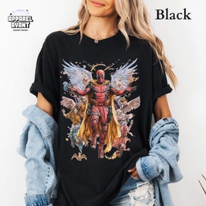 Black Comfort Colors t-shirt showcasing Funny Deadpool as Jesus, a hilarious Marvel parody design for fans of the Merc with a Mouth. Soft, heavyweight cotton with a faded wash, relaxed fit, and durable stitching. A bold Deadpool 3 movie graphic tee for lovers of superhero humor, meta-comedy, and sarcastic wit. Ideal for comic book collectors, Ryan Reynolds fans, and those who enjoy Deadpool’s chaotic and unfiltered personality. Perfect for everyday wear or as a standout statement piece.