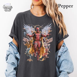 Pepper Comfort Colors t-shirt featuring Funny Deadpool as Jesus, blending humor with Marvel’s iconic anti-hero. Heavyweight, vintage-washed cotton with an oversized fit for all-day comfort. A must-have Deadpool 3 movie tee for fans of sarcastic superheroes, witty comic book humor, and irreverent pop culture mashups. Perfect for casual wear, comic conventions, and anyone who loves Deadpool’s outrageous. Designed for Marvel fans who appreciate bold, hilarious, and one-of-a-kind superhero shirts.