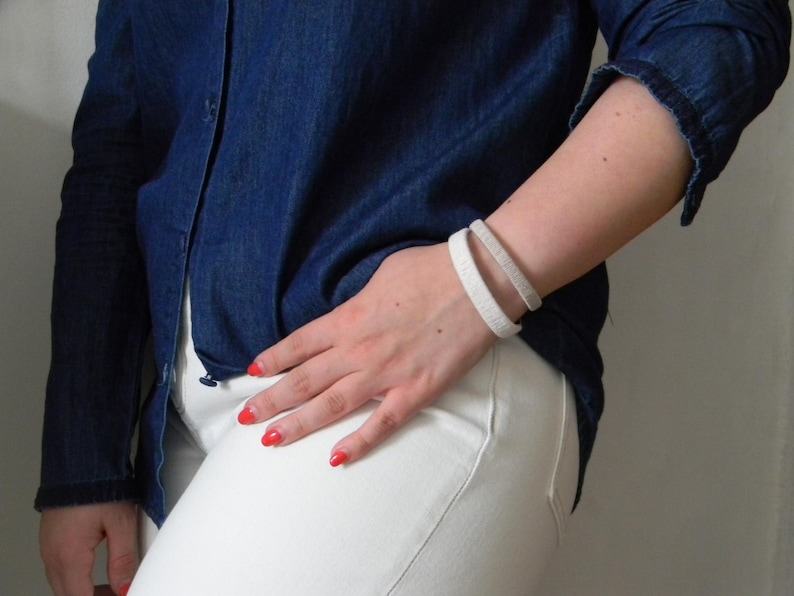 Woman wearing two cuff bracelets on her wrist. Wool and metal bracelets for the seventh wedding anniversary, the wool anniversary.