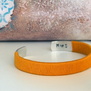 Metal and cotton bracelet with inner personalised engraving. Initials with heart. Yellow cotton thread. Gift for wife, second wedding anniversary gift. Cotton anniversary. The bracelet is adjustable because it has a open part.