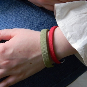 A model wearing personalized metal and cotton bracelets. Custom engraving for cotton anniversary.