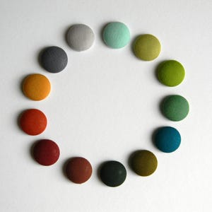 Ronde reversspeld. Stoffen boutonnière. Effen kleuren. Zakelijke stijl. Bedrijfskleur. Evenement. Kantoorkleding.