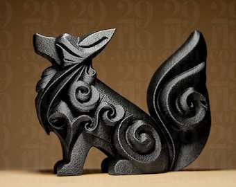 May include: A black fox ornament featuring detailed swirling designs. The fox is depicted in a seated pose with its tail curled. The sculpture has a textured finish and is made from a dark, solid material.