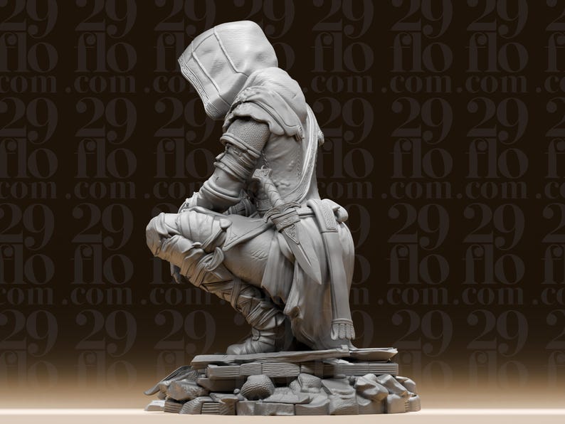 May include: A detailed, grey figurine of a hooded figure in a crouching position, possibly a character from a fantasy or historical setting. The figure is wearing armour and a hood, with a sword at the waist. The base is a textured, rocky surface.