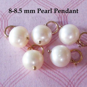 May include: Six white pearl pendants with gold jump rings. The pearls are 8-8.5 mm in size.