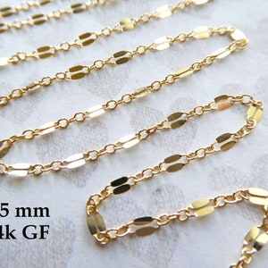 May include: A gold chain necklace with a 2.5 mm flat oval link design. The chain is made of 14k gold-filled metal.