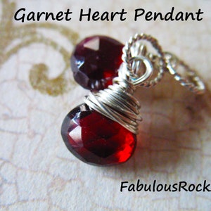 May include: Two red garnet heart pendants wrapped in silver wire. The pendants are attached to a silver chain.