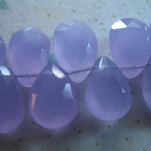 Puede incluir: Una hebra de cuentas de piedras preciosas de color p&uacute;rpura claro, cada cuenta est&aacute; facetada y tiene forma de l&aacute;grima.