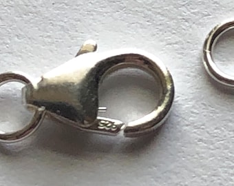 May include: Silver clasp and jump ring for jewelry making. The clasp has a spring-loaded closure and a small loop for attaching to a chain. The jump ring is a simple circle.