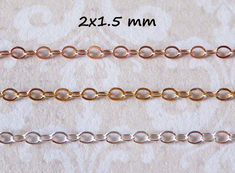 Puede incluir: Tres hebras de cadena, de 2x1,5 mm de tama&ntilde;o, en oro rosa, oro y plata. Las cadenas est&aacute;n dispuestas horizontalmente sobre un fondo de tela blanca.