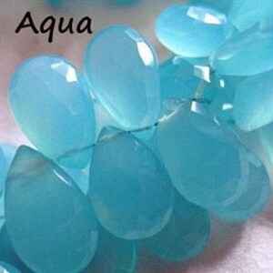 Pu&ograve; includere: Una collana di perle di pietra preziosa blu acquamarina, ogni perla ha la forma di una lacrima. Le perle sono infilate su un filo d'argento.