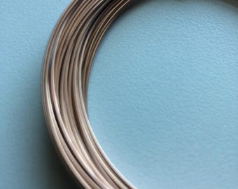 Può includere: Primo piano di una bobina di filo color oro. Il filo è avvolto strettamente, creando una forma circolare liscia.