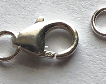 May include: Silver clasp and jump ring for jewelry making. The clasp has a spring-loaded mechanism and a small loop for attaching to a chain. The jump ring is a simple circle.