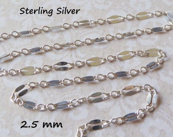 May include: A close-up of a sterling silver chain featuring oval and circular links. The chain is 2.5 mm wide. The text "Sterling Silver" is visible in the image.