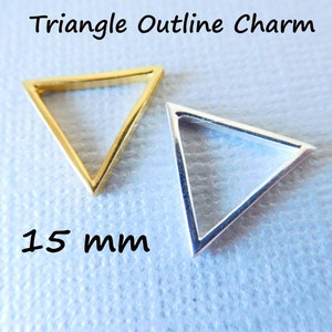 Op de afbeelding: Twee driehoekige omtrekcharms, een gouden en een zilveren, met een maat van 15 mm.  Driehoekige omtrekcharm.