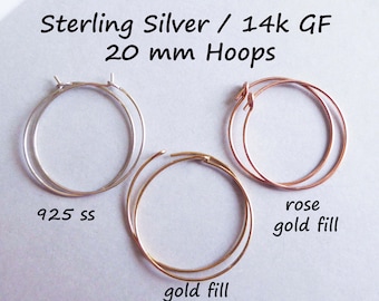 May include: Three pairs of hoop earrings in different finishes: sterling silver, gold fill, and rose gold fill. Each pair is 20 mm in diameter. The text "925 ss" is written below the sterling silver hoops, and the text "gold fill" is written below the gold fill hoops. The text "rose gold fill" is written below the rose gold fill hoops.