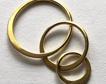May include: Three interlocking gold-colored metal rings of different sizes.