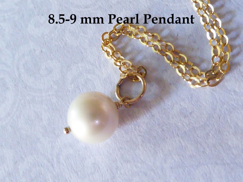 May include: A white pearl pendant on a gold chain. The pearl is 8.5-9 mm in diameter.
