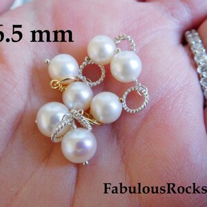 May include: A close-up of a strand of white pearls with silver and gold accents. The pearls are 6.5 mm in diameter.