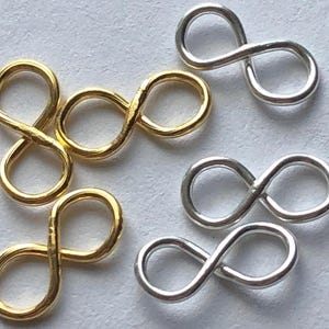 May include: A set of gold and silver infinity symbol charms. The charms are made of metal and are perfect for jewelry making.