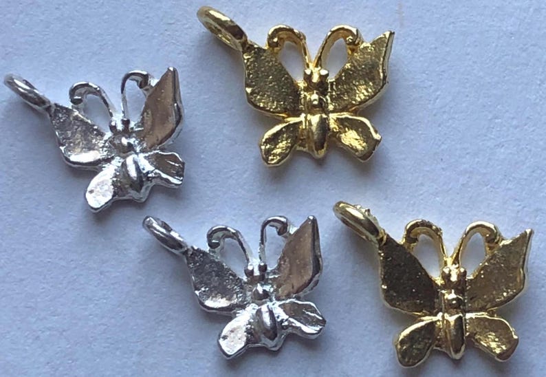 Puede incluir: Cuatro abalorios de mariposa, dos plateados y dos dorados, con un dise&ntilde;o detallado. Los abalorios son perfectos para la elaboraci&oacute;n de joyas o para a&ntilde;adir un toque de fantas&iacute;a a cualquier proyecto.