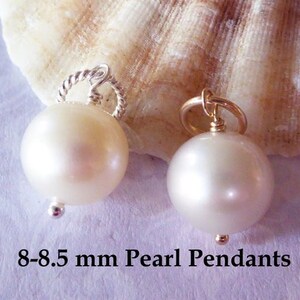 May include: Two white pearl pendants, one with a silver bail and one with a gold bail. The pearls are 8-8.5 mm in diameter. 8-8.5 mm Pearl Pendants