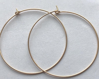 Puede incluir: Un par de pendientes de aro de oro. Los aros son simples y elegantes, y son perfectos para el uso diario.