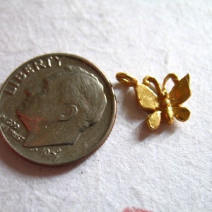 Puede incluir: Un dije de mariposa de color dorado. El dije es aproximadamente del tama&ntilde;o de una moneda de diez centavos.
