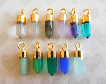 May include: Twelve gold-capped crystal point pendants in various colors, including clear, white, gray, pink, purple, green, and blue.