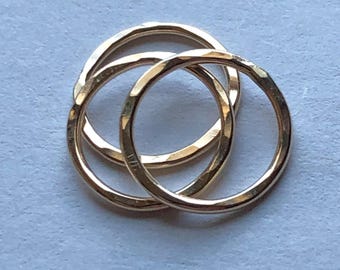 May include: Three gold rings, each with a hammered texture, are stacked on top of each other.