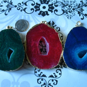 May include: Three agate slice pendants with gold trim. The slices are green, red, and blue.