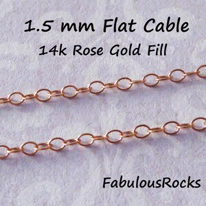 Puede incluir: Dos hebras de cadena de cable plana de 1,5 mm en oro rosa de 14 quilates. La cadena est&aacute; hecha de eslabones ovalados y se muestra sobre una superficie blanca. FabulousRocks.