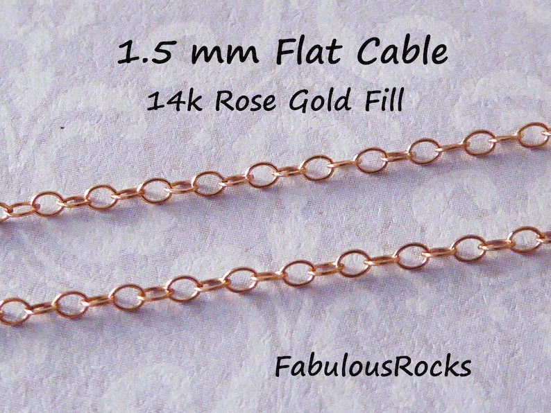 Puede incluir: Dos hebras de cadena de cable plana de 1,5 mm en oro rosa de 14 quilates. La cadena est&aacute; hecha de eslabones ovalados y se muestra sobre una superficie blanca. FabulousRocks.