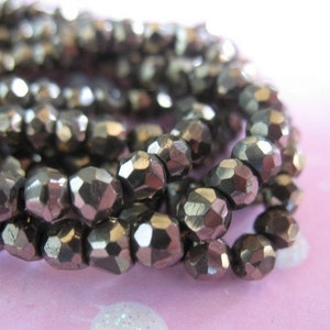 May include: A strand of silver-toned faceted glass beads. The beads are small and have a metallic sheen.