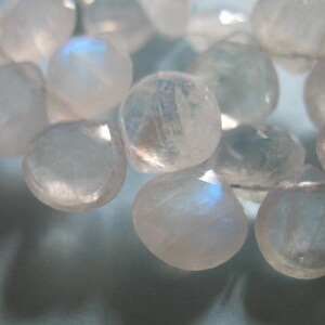 May include: A strand of iridescent moonstone beads, each bead is a light, milky white with a subtle shimmer.