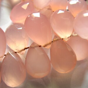 Pu&ograve; includere: Una collana di perle di calcedonio rosa, ogni perla &egrave; sfaccettata e a forma di lacrima.
