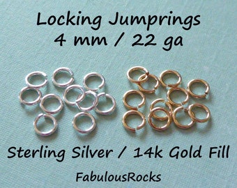Può includere: Due pile di anelli di salto a chiusura da 4 mm, calibro 22. Una pila è in argento sterling e l'altra è in oro 14 carati. Gli anelli di salto sono su uno sfondo blu chiaro. Il testo "Locking Jumprings 4 mm / 22 ga Sterling Silver / 14k Gold Fill FabulousRocks" è visibile nell'immagine.