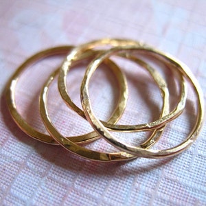 May include: Four gold-toned stacking rings with a hammered texture.