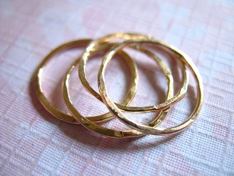 May include: Four gold-toned stacking rings with a hammered texture.