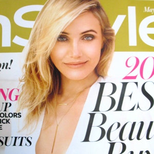 May include: A magazine cover featuring a woman with blonde hair wearing a white top and a gold necklace. The magazine cover text reads "InStyle" and "20 Best Beauty Buys".