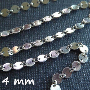 May include: Silver chain with round, flat links. Each link is approximately 4 mm in diameter. The chain is shown in a close-up view.