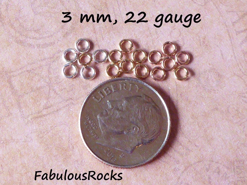 May include: A close-up of a pile of 3 mm, 22 gauge jump rings. The rings are silver and gold in color. A US dime is shown for size comparison.