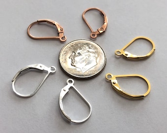 Puede incluir: Un surtido de cierres de pendientes en tonos cobre, plata y oro. Los cierres tienen varias formas, incluyendo estilos de palanca. Se incluye una moneda de diez centavos estadounidense como referencia de tamaño.