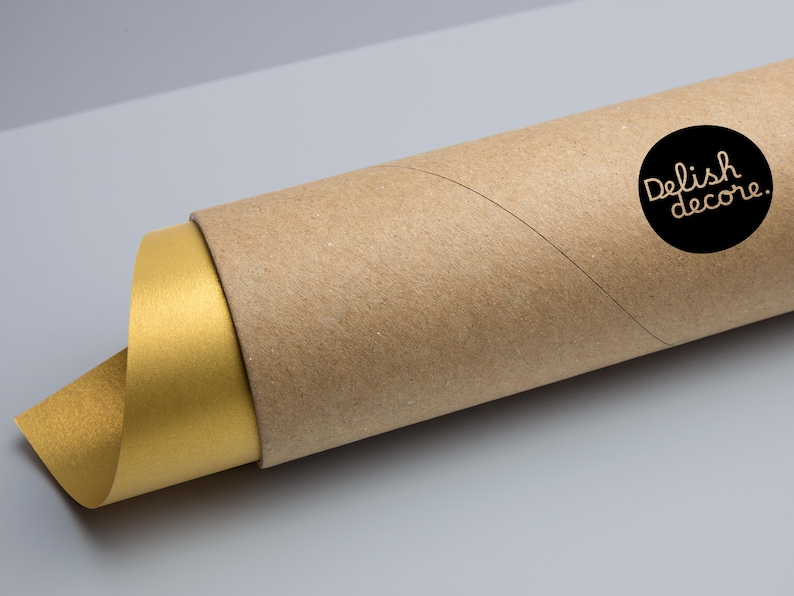 Puede incluir: Un p&oacute;ster o impresi&oacute;n enrollada, con una superficie dorada visible en el extremo. El p&oacute;ster est&aacute; encerrado en un tubo de cart&oacute;n marr&oacute;n. Una pegatina circular negra con el texto "Delish decore." est&aacute; en el tubo.