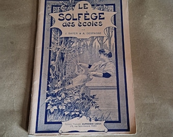 May include: Vintage French music book titled "LE SOLFÈGE des écoles" by J. Bayer & A. Despagne. The cover features a blue and white illustration of a woman with a musical instrument. The book is from Editions Musicales Alphonse Leduc, Paris.