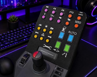 May include: A black gaming control deck featuring a joystick, a scroll wheel, and a grid of colorful buttons. The buttons are arranged in rows and columns with various icons and text labels including PTO, Fold, Unfold, SEED, and AUTO in white.