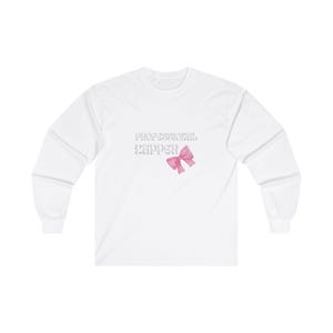 Puede incluir: Camiseta blanca de manga larga con el texto "Professional Zapper" en una fuente de brillo plateado y un lazo rosa.