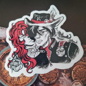 May include: A sticker with a black and white illustration of two figures in a steampunk style. One figure has red hair and is embracing the other, who wears a hat with a feather and a military-style jacket. The background features gears and clock parts.