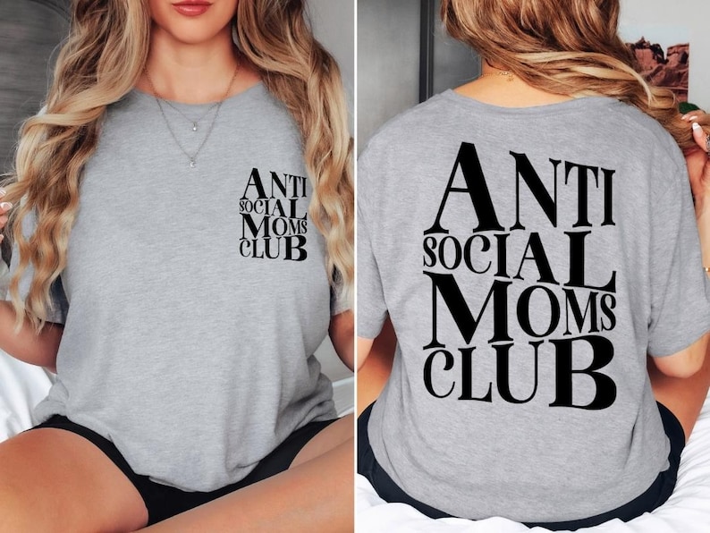 Op de afbeelding: Grijs T-shirt met de tekst "Anti Social Moms Club" in zwart gedrukt op de voor- en achterkant.