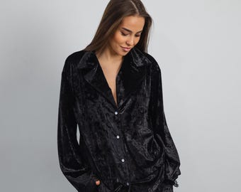 May include: A black velvet pajama top with a button-up front and long sleeves. The top has a slightly oversized fit and a relaxed collar.